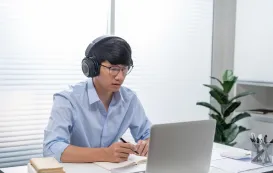 web会議イヤホンマイクをつけてオンライン会議をしている男