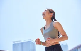 ランニングイヤホンをつけてランニングしている女