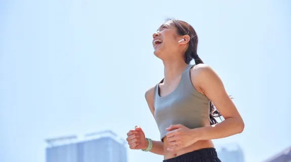 ランニングイヤホンをつけてランニングしている女