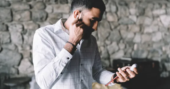 ワイヤレスイヤホンで通話している男