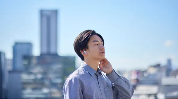 ハンズフリーイヤホンをつけて通話している男