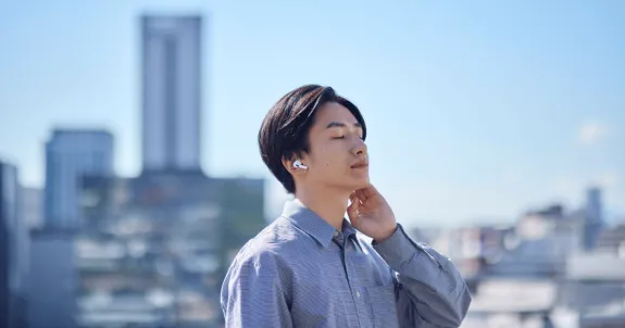 ハンズフリーイヤホンをつけて通話している男