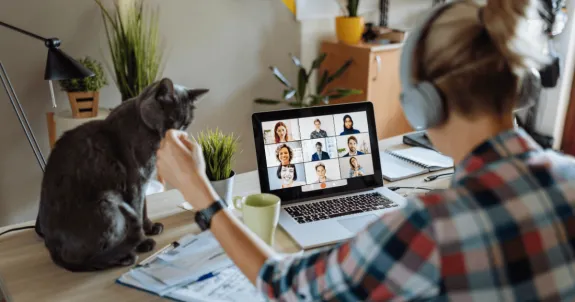 仕事中にイヤホンをつけてWeb会議を参加している女