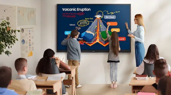2 students are drawing some details about an volcanic eruption on a smartboard