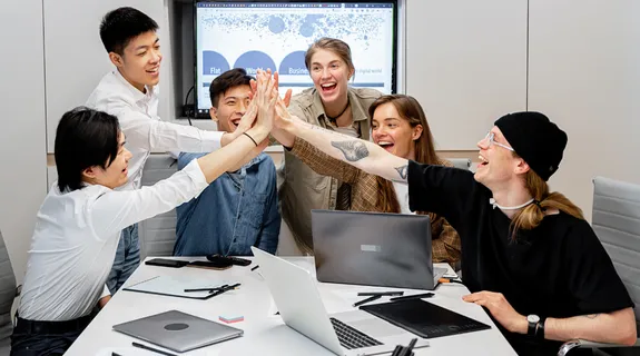 数人が集まって、Teamsのホワイトボードの使い方について会議をしています。