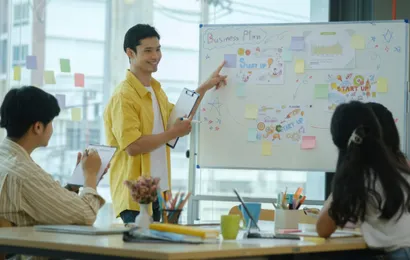 男性がかっこいいホワイトボードを使ってプレゼンしている