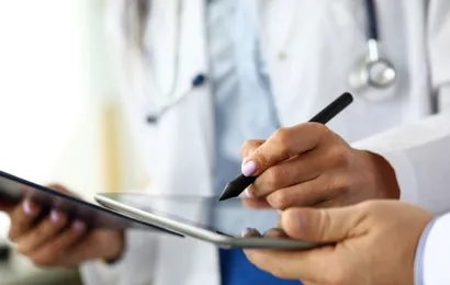 一人が電子メモを手に持ち、真剣にメモを取っている