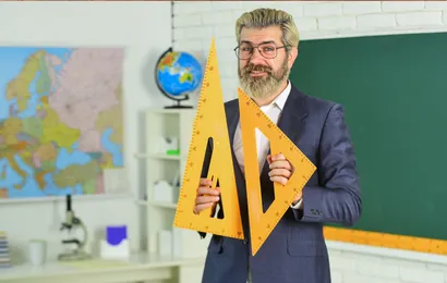 男性教師が定規で黒板のサイズを測ろうとしています。