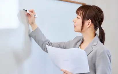 一人の女性がホーローホワイトボードに今まさに文字を書こうとしている