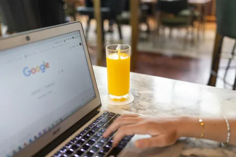 a women search something on the google with a orange juice
