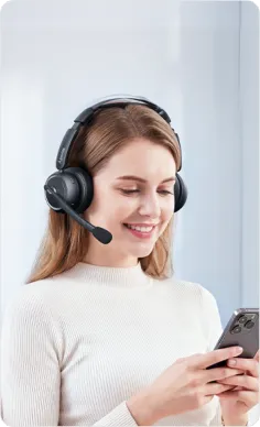 Smiling professional woman comfortably wearing over ear noise cancelling headphones, ideal headphone for call center.