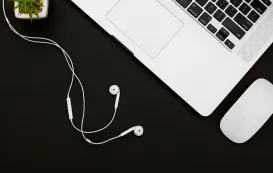 a computer and best earbuds for meetings lying on the table