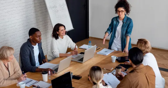 seven people wearing earbuds for meetings in a room