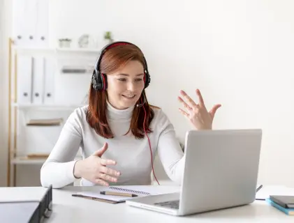 Woman wearing noise cancelling headphones while practicing online language speaking