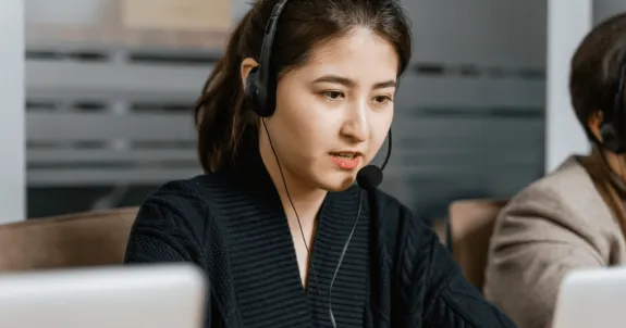 ノイズキャンセリングマイクを使って話している女