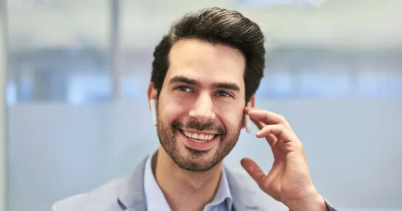 ワイヤレスイヤホンで電話している男