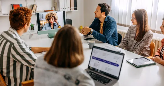 会議アジェンダを従ってハイブリッド会議をしている会社員