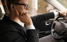 開放型イヤホンNearity MemPod Fit 2で通話しながら運転している男