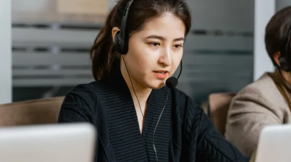 ノイズキャンセリングマイクを使って話している女
