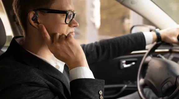 開放型イヤホンNearity MemPod Fit 2で通話しながら運転している男