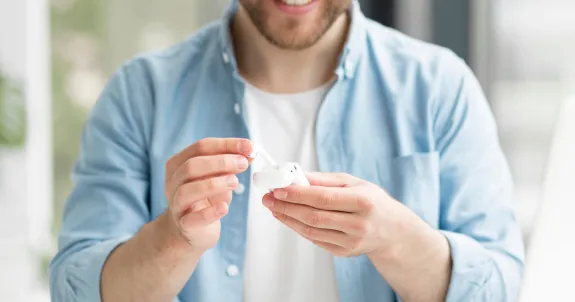 this male is looking at his low latency bluetooth earbuds