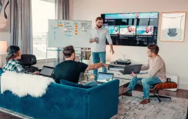 A family smiling while using an  interactive whiteboard in their living room as a digital family calendar and creative drawing board
