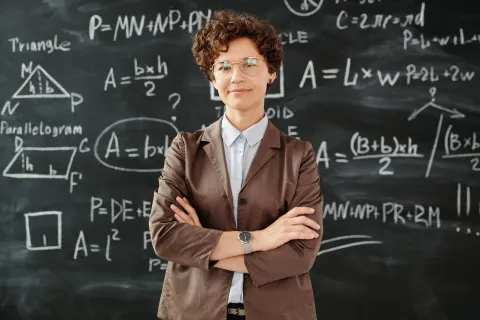 math teacher stands before a blackboard