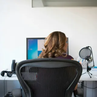 A woman sits beside the best ergonomic office chair