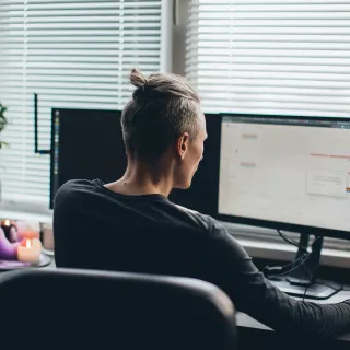 A man's neck hurts sitting at desk