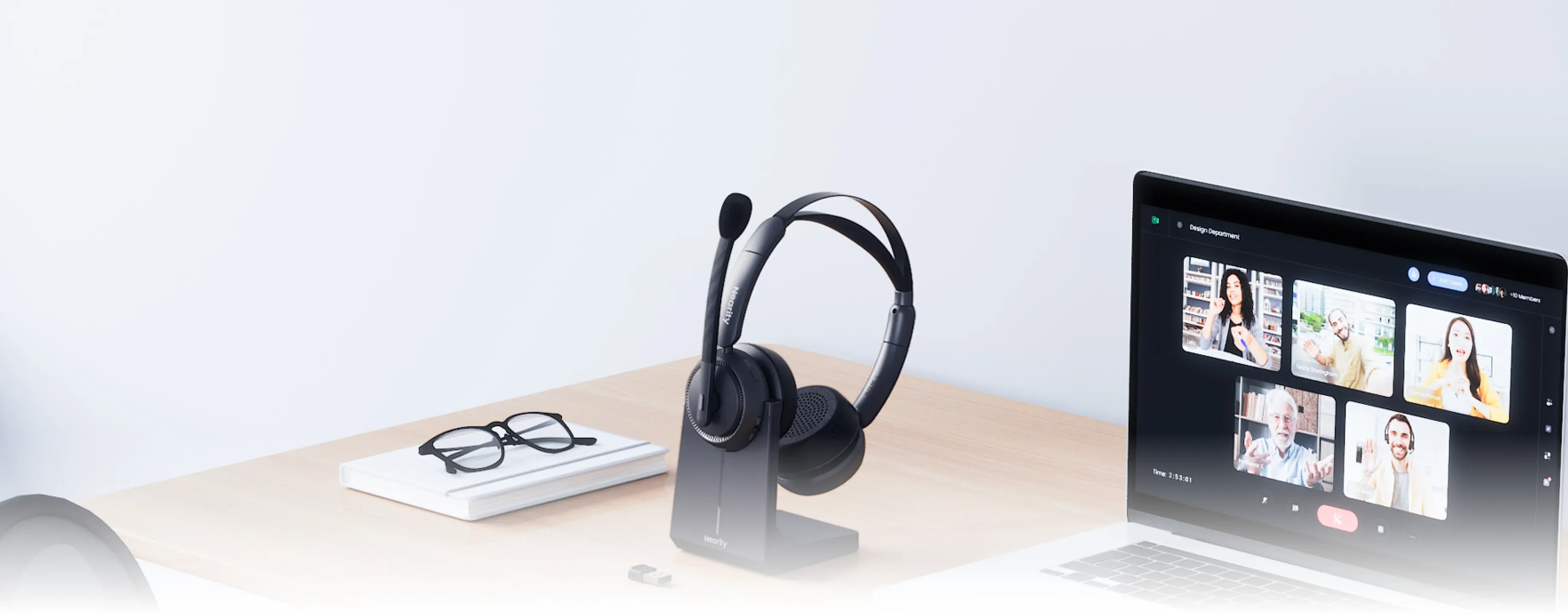 Noise cancelling headphones for work from home resting on a desk charging base.