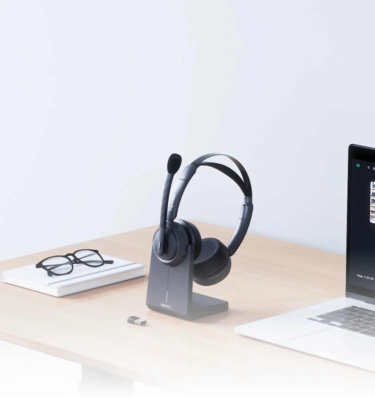 Noise cancelling headphones for work from home resting on a desk charging base.