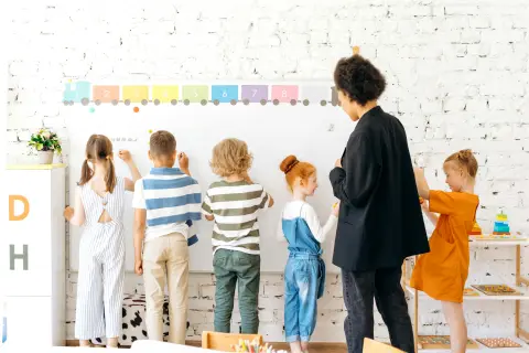 Students smiling while participating in a fun whiteboard drawing