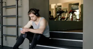 スポーツ用ワイヤレスイヤホンを付けている男