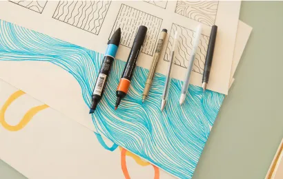 画紙の上に6本のカラフルな極細ホワイトボードマーカーがあります。