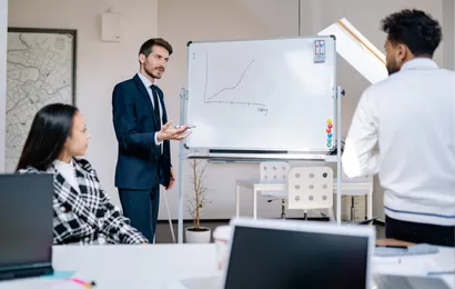 ホワイトボードの前でホワイトボードの代わりになるものを議論する3人の男たち