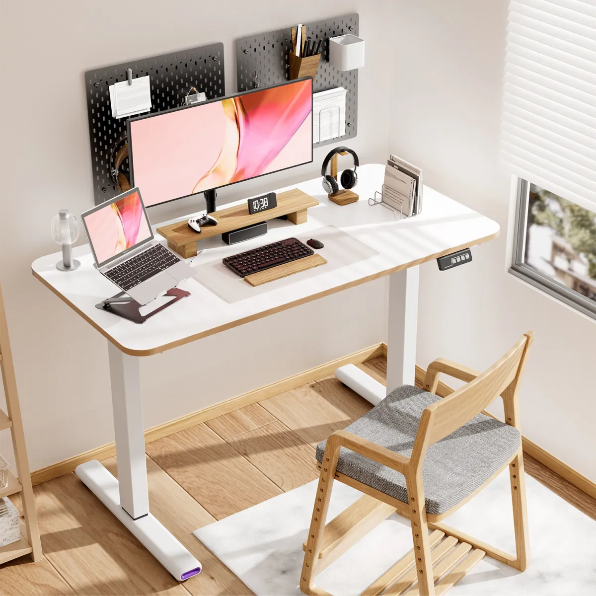 Two computers on a white electric sit to stand desk
