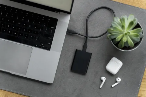 Top view of a modern desk arrangement with SSD laptop, showcasing a clean workspace for hybrid work and productivity.